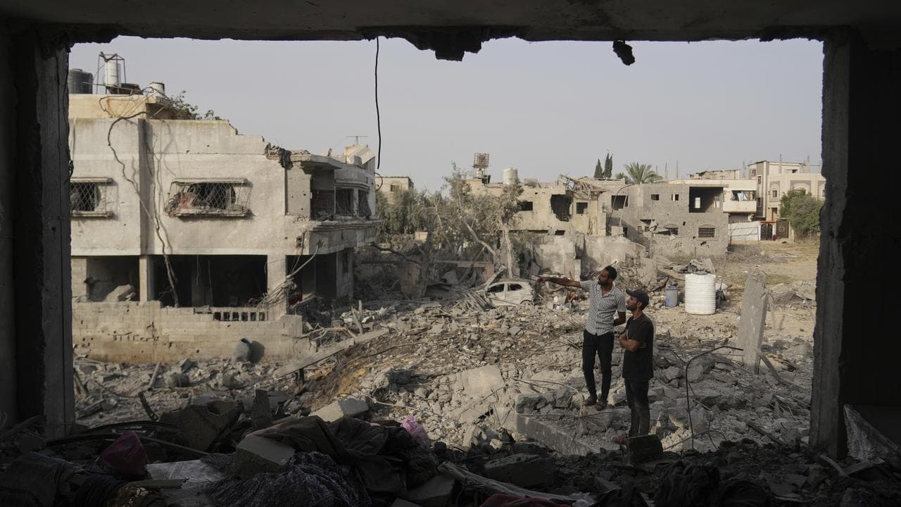 Palestinians inspect the rubble of a family's Gaza home