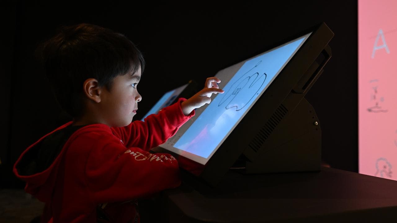 A child draws on a tablet