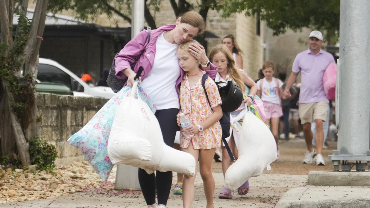 A woman and a child embrace after girls from Camp Waldemar