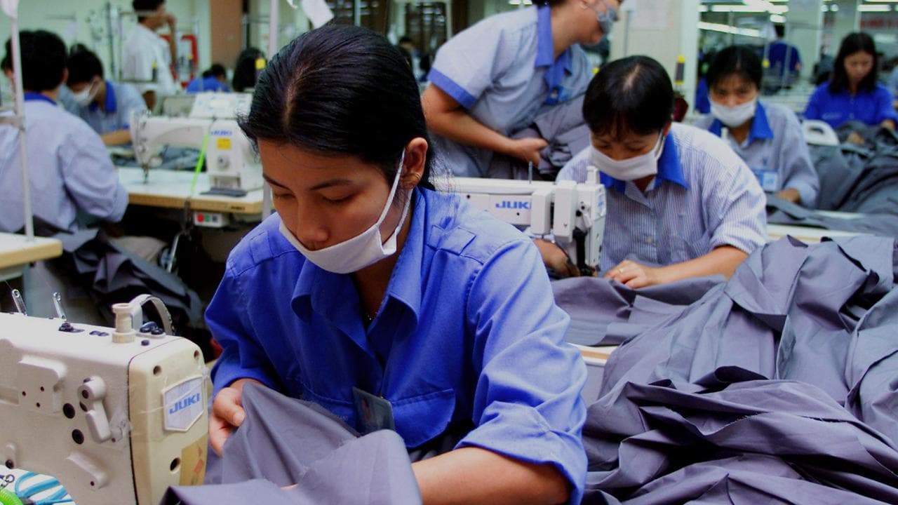Vietnamese workers sew men's shirts for export
