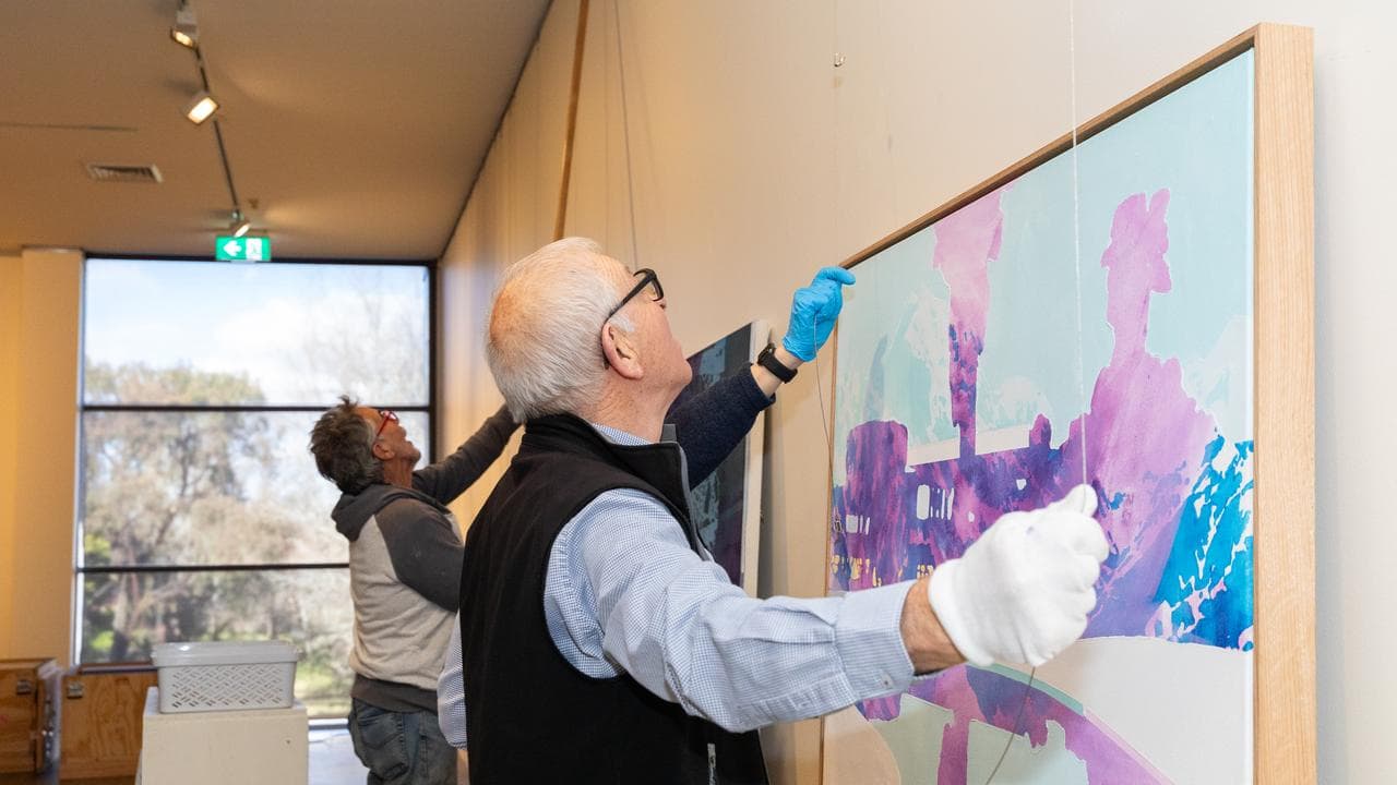 Gallery supporters help to install artworks for an upcoming exhibition