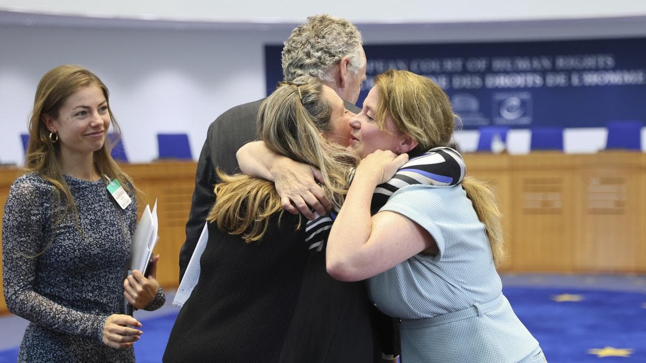 People hug after the European Court of Human Rights rules on Russia
