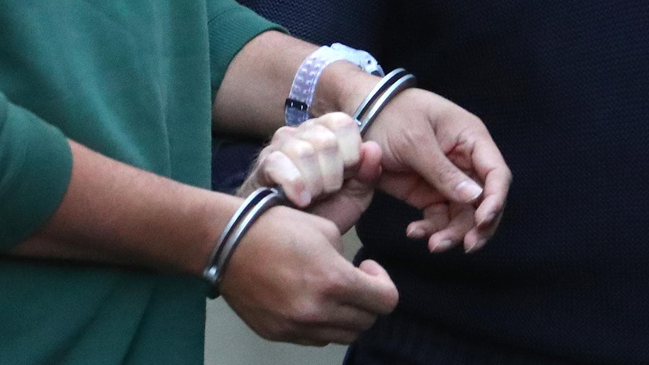 A prisoner is led by handcuffs (file image)