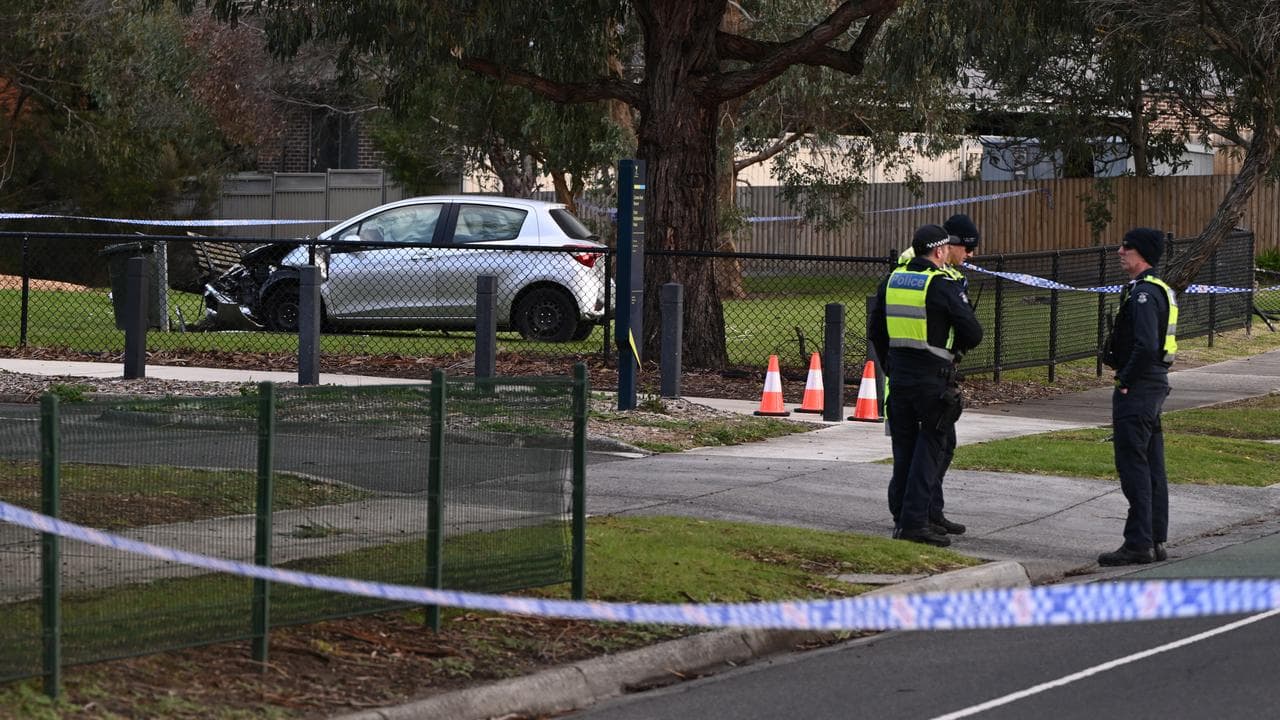 Police at the scene where a car crashed into a playground