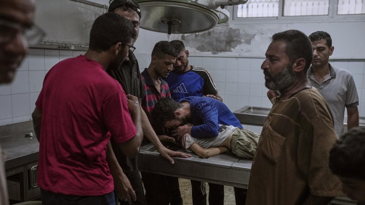 Palestinians mourn a child killed in an Israeli military airstrike
