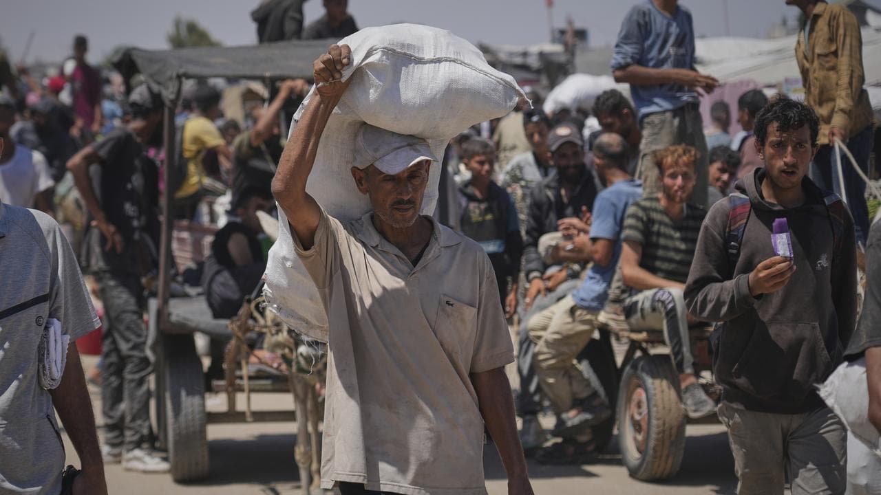 Palestinians carry food and humanitarian aid