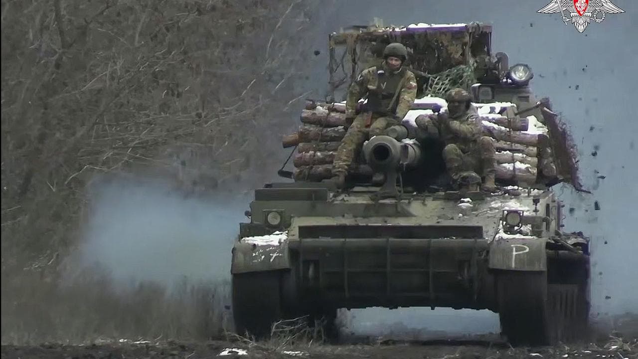 Russian soldiers ride atop Akatsiya self-propelled gun