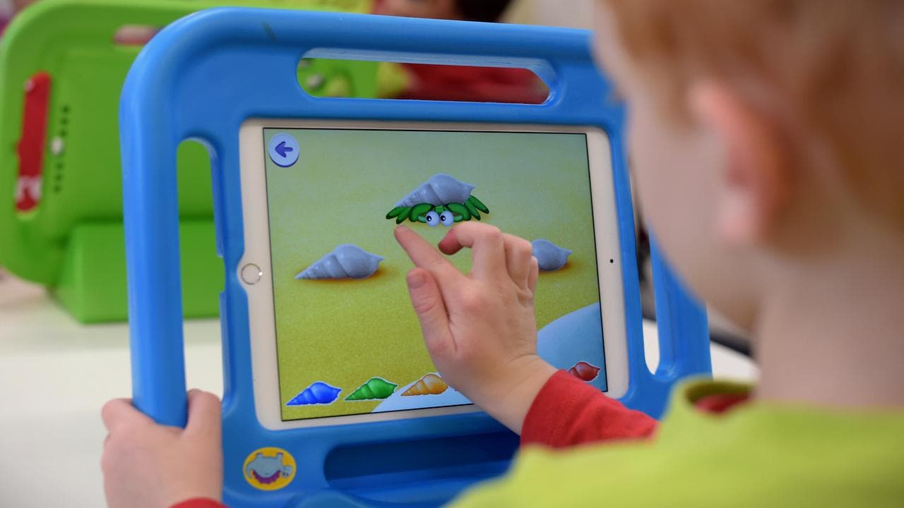 Boy plays with iPad at a childcare centre