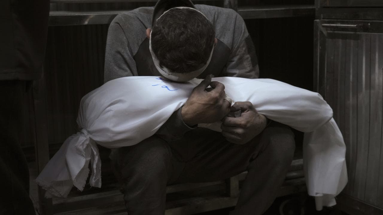 Hossam Azzam holds the body of his child