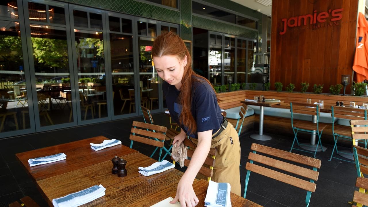 Wait staff member sets a table