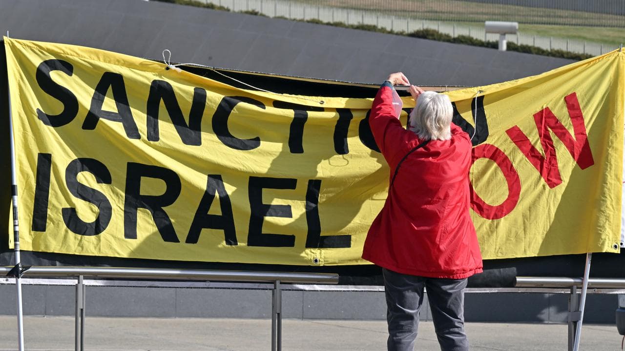 A pro-Palestinian protester putting up a sign