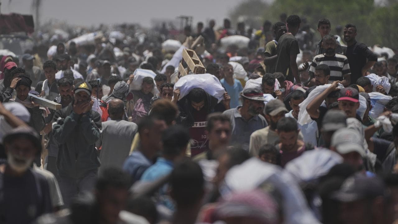 Palestinians carrying food from the Gaza Humanitarian Foundation