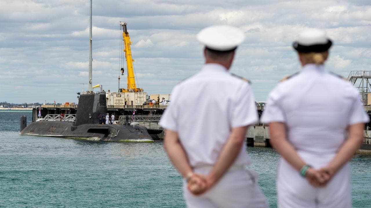 Australian Navy personnel look at a UK nuclear-powered submarine