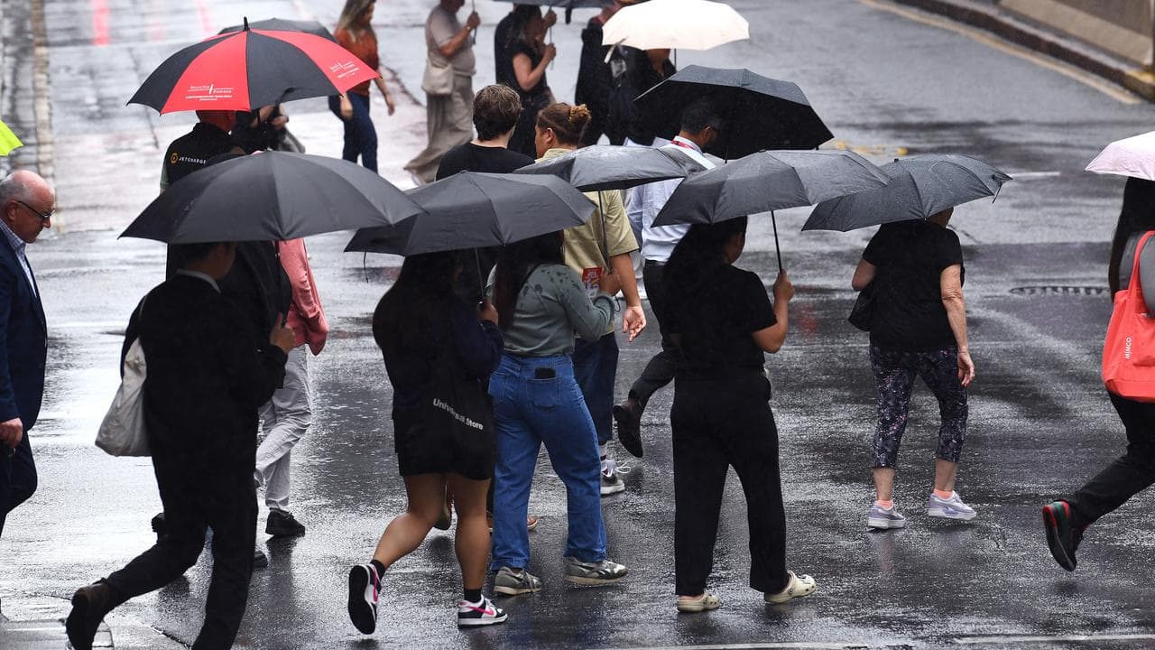 People in the CBD walk through wet weather in Brisbane