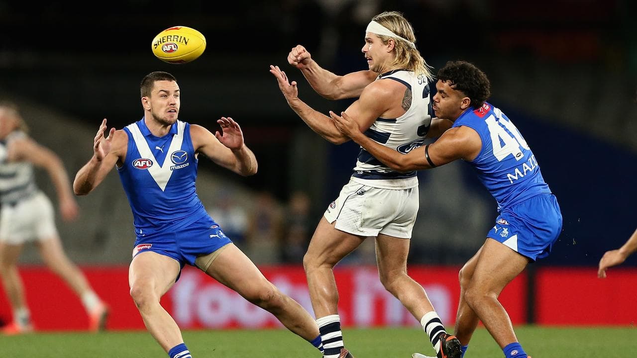 The Cats' Bailey Smith fires out a handball.