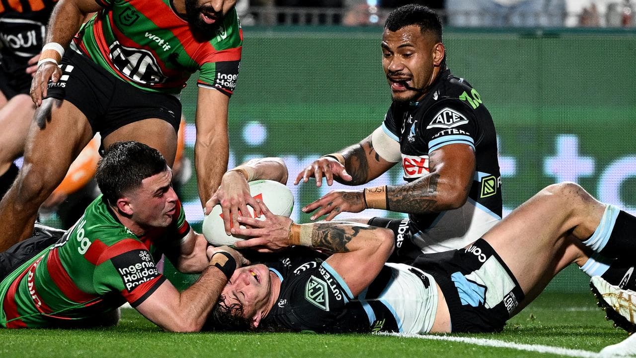 Nicho Hynes is denied a try by South Sydney's Lewis Dodd.