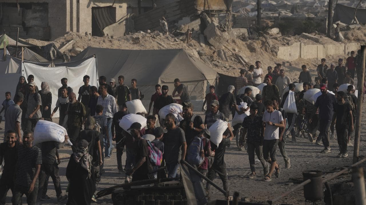 Palestinians carry sacks of flour that reached Gaza City