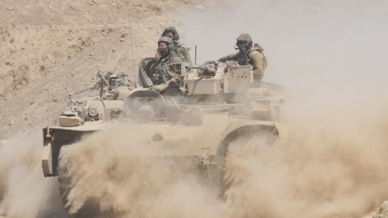Israeli soldiers drive an armoured personnel carrier