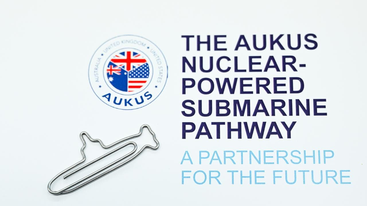 an AUKUS logo on a press brochure