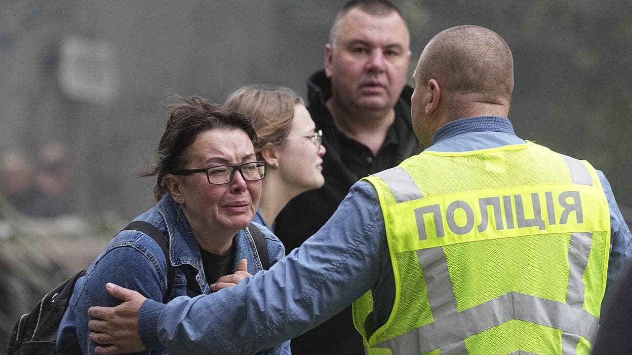 Women cries outside a destroyed apartment building in Kyiv, Ukraine