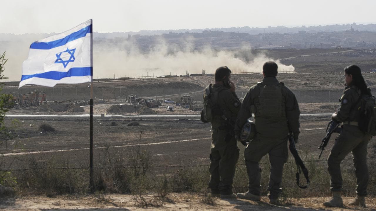 Israeli soldiers watch the northern Gaza Strip from southern Israel