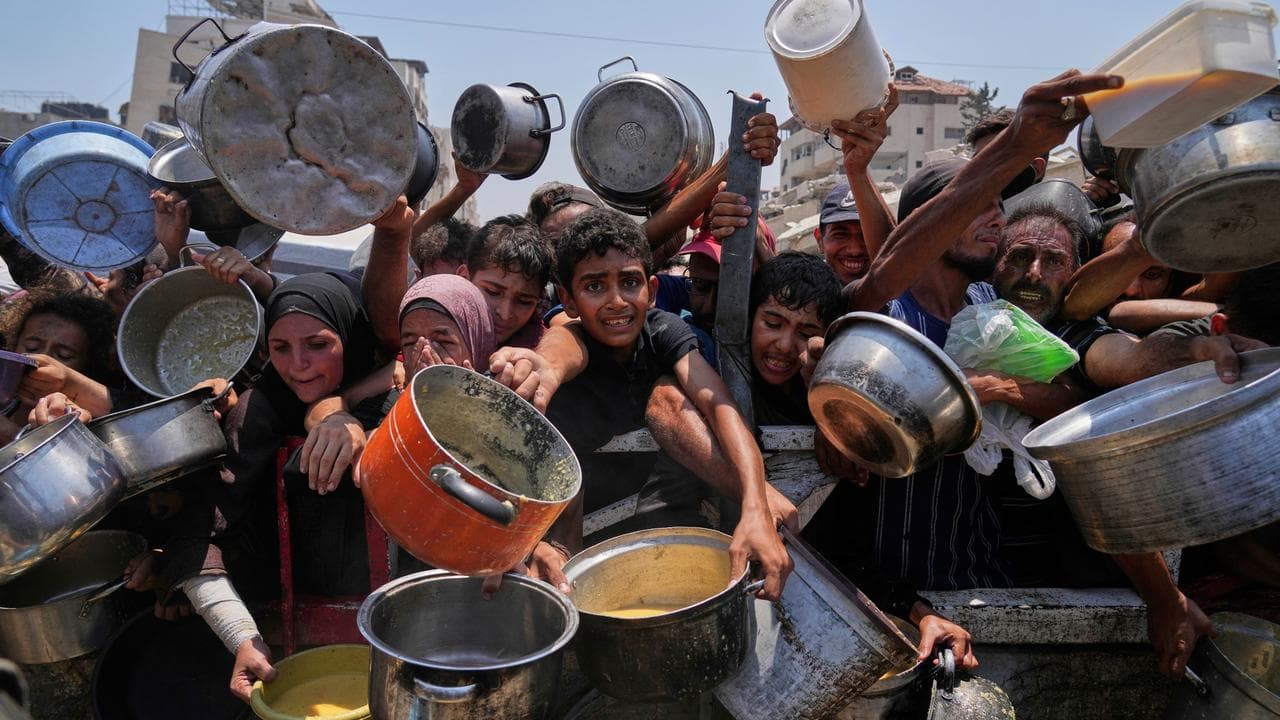 Palestinians struggle to get food at a community kitchen in Gaza City