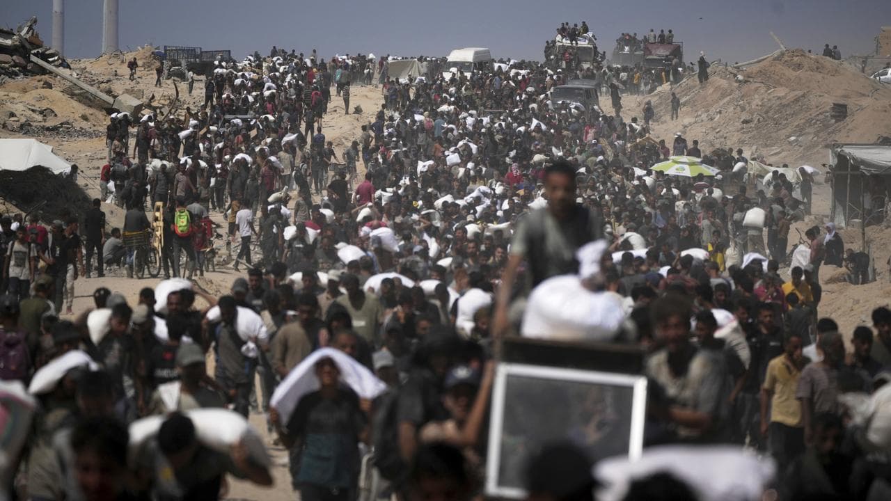 Palestinians carry sacks of flour taken from a humanitarian aid convoy