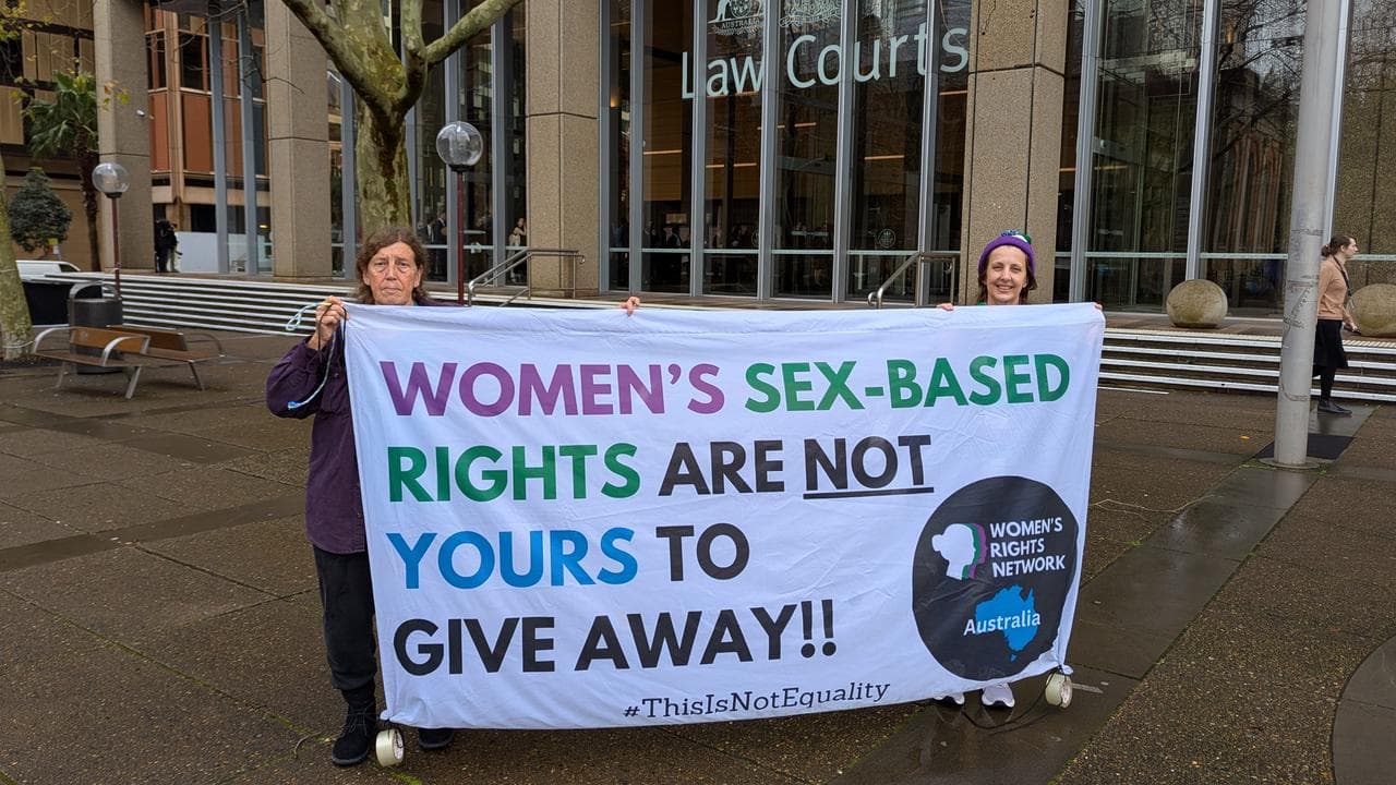 Activists supporting Giggle for Girls hold a banner outside court
