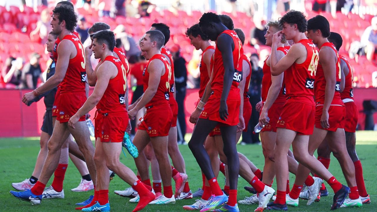 Disappointed Suns players walk off the field.