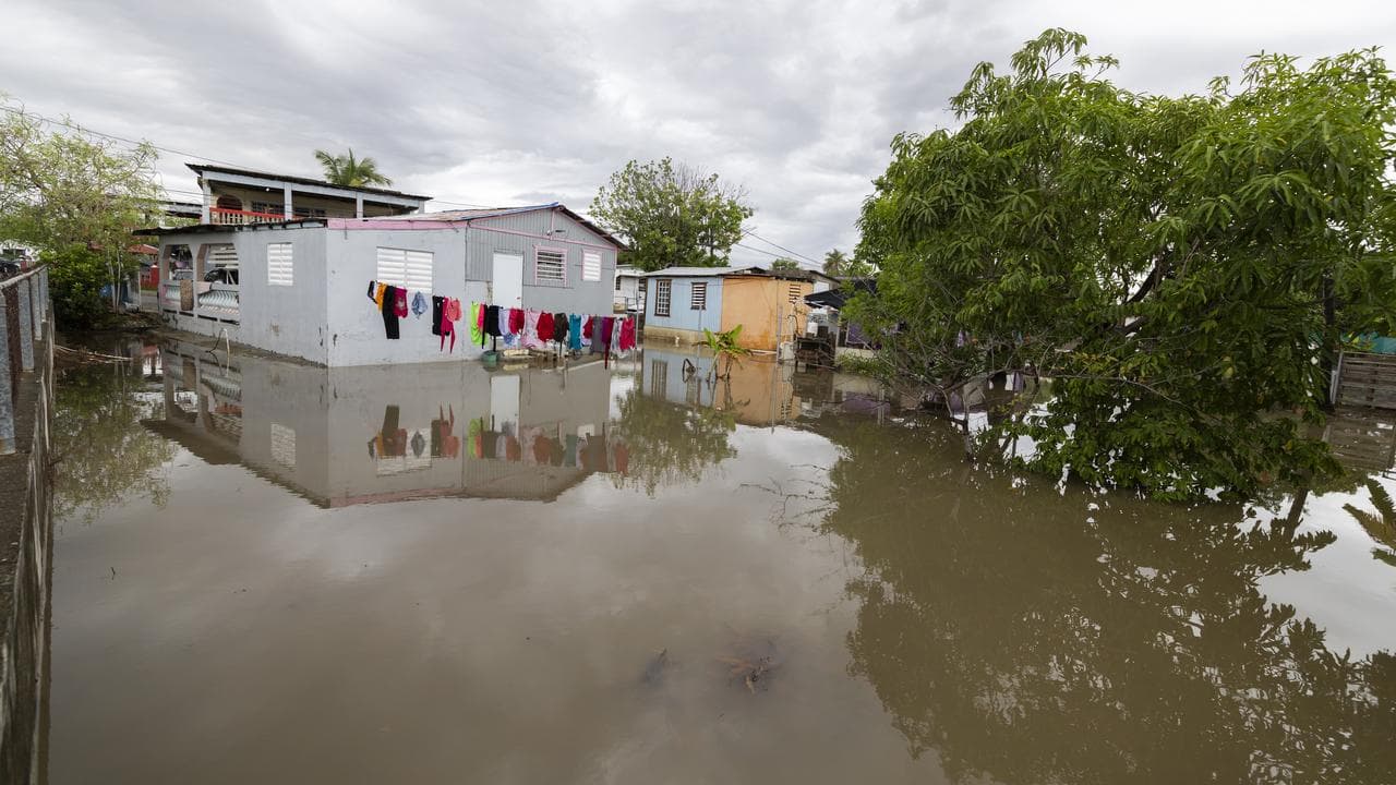 Water surrounds a house in Guayama, Puerto Rico