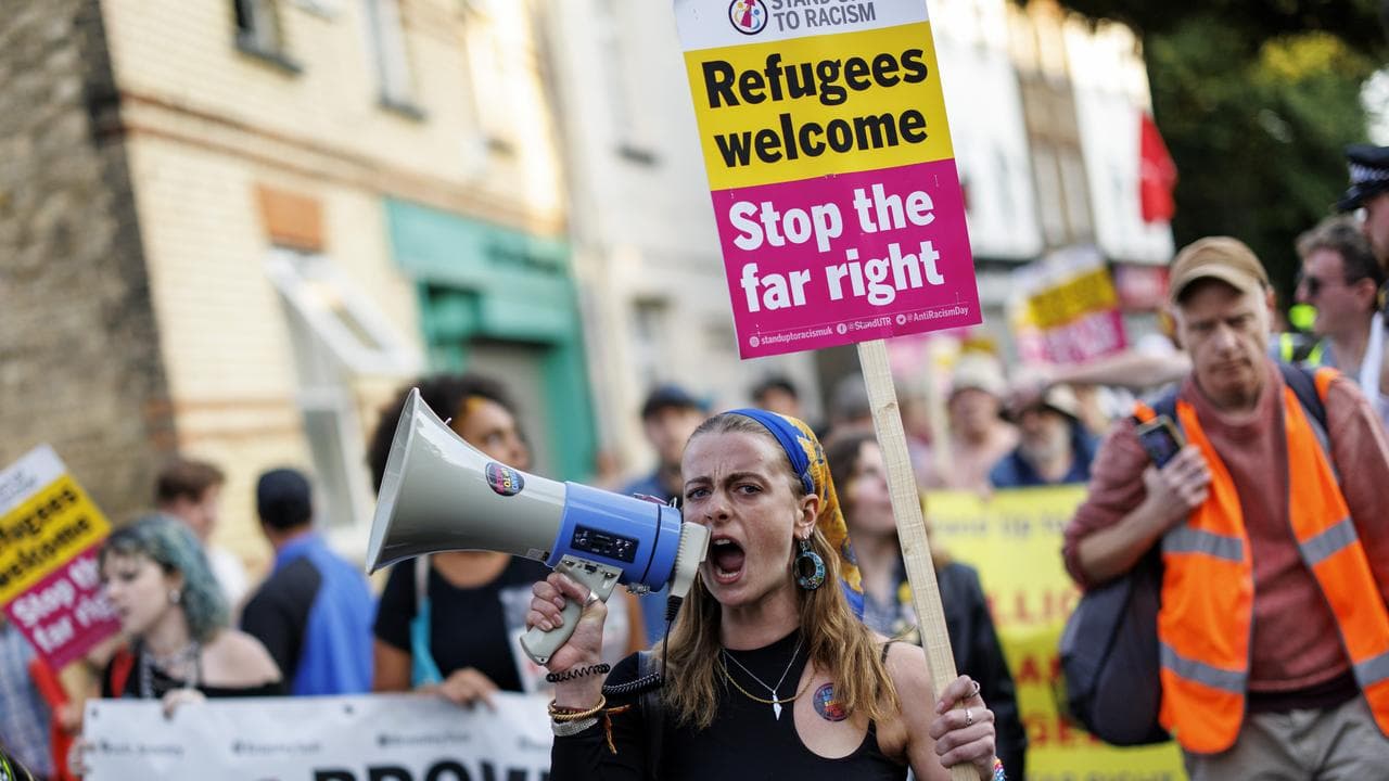 A protester with placards and a megaphone