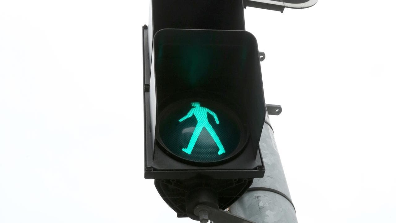 A stock image of a green pedestrian traffic sign