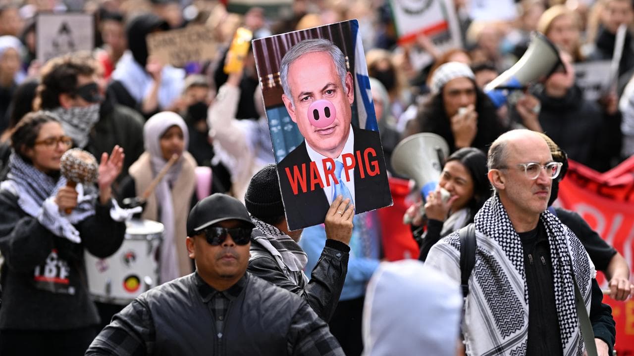 A protester holds up a placard of Benjamin Netanyahu