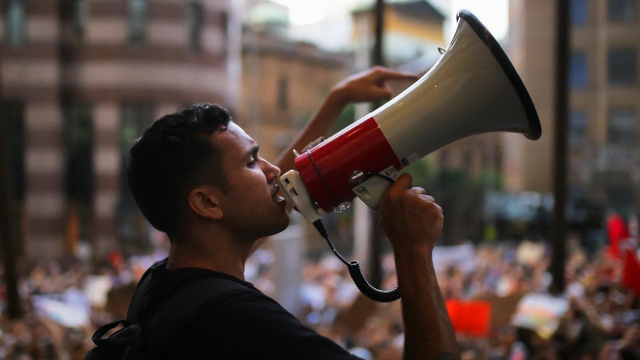 Man chants on a megaphone at rally in Sydney, Friday, January 10, 2020