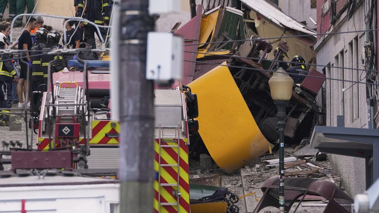 Emergency teams work at the site of a derailed streetcar in Lisbon