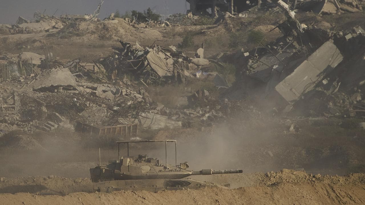 Israeli soldiers drive a tank inside the Gaza Strip