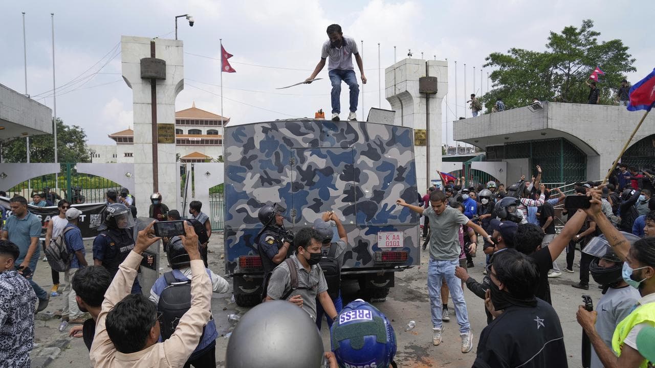 Protesters surround an armoured vehicle outside Nepal's parliament