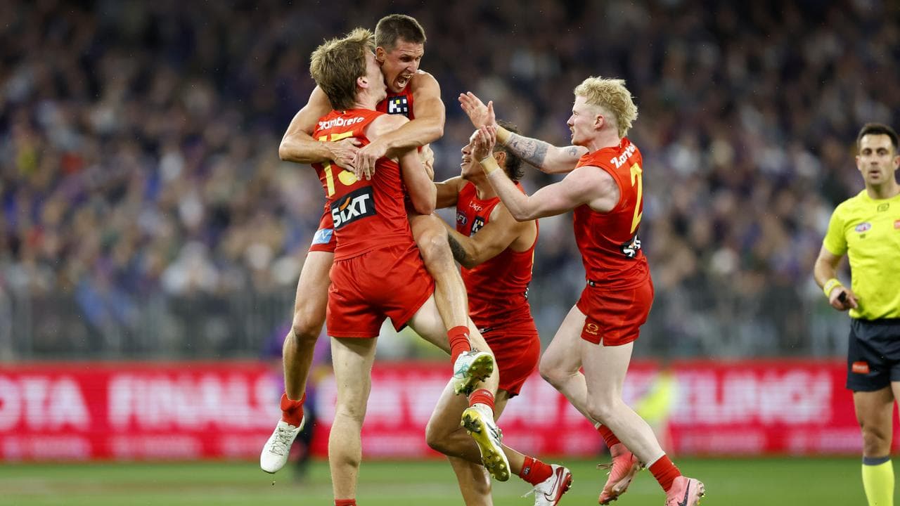 Gold Coast teammates swamp veteran David Swallow.