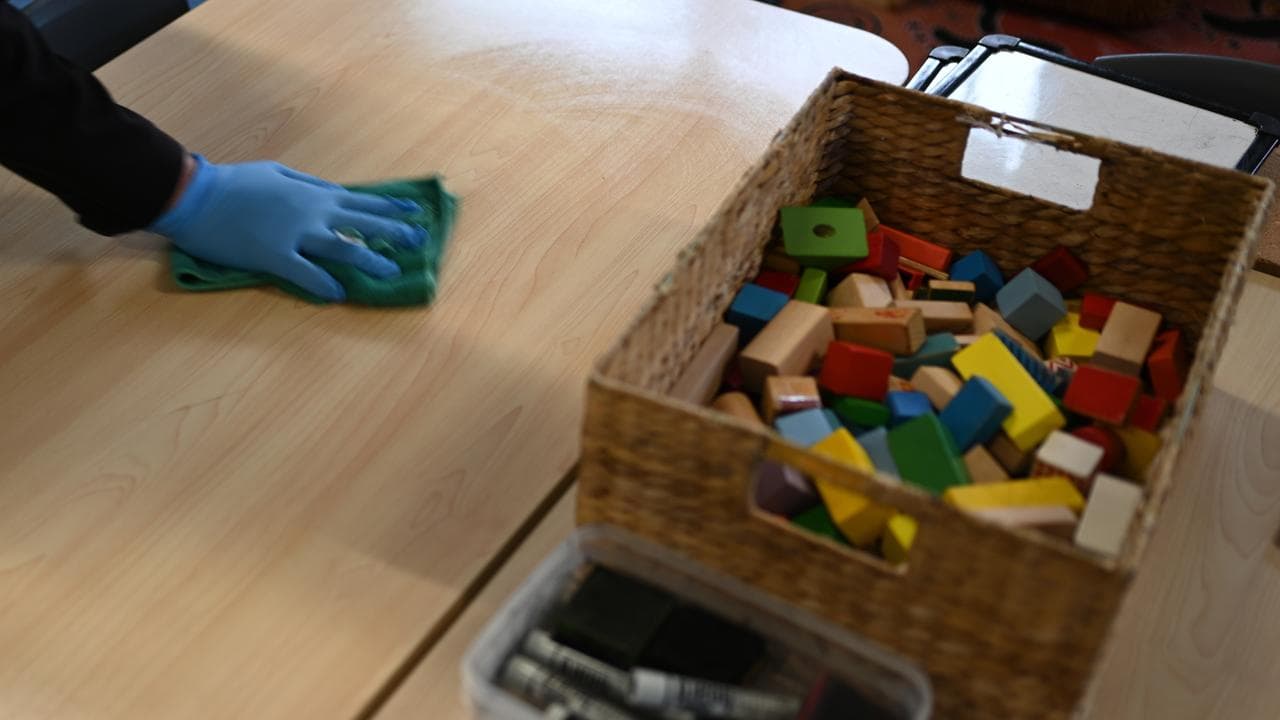 Childcare worker wipes table (file)