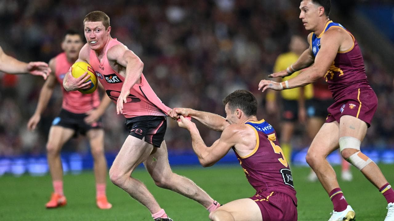 Matt Rowell (left) of the Suns is grabbed by Josh Dunkley.