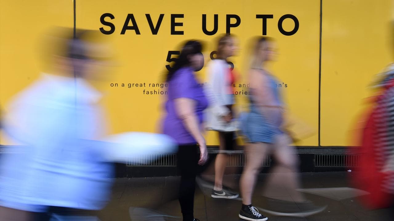 Pedestrians walks past an advertisement (file image)