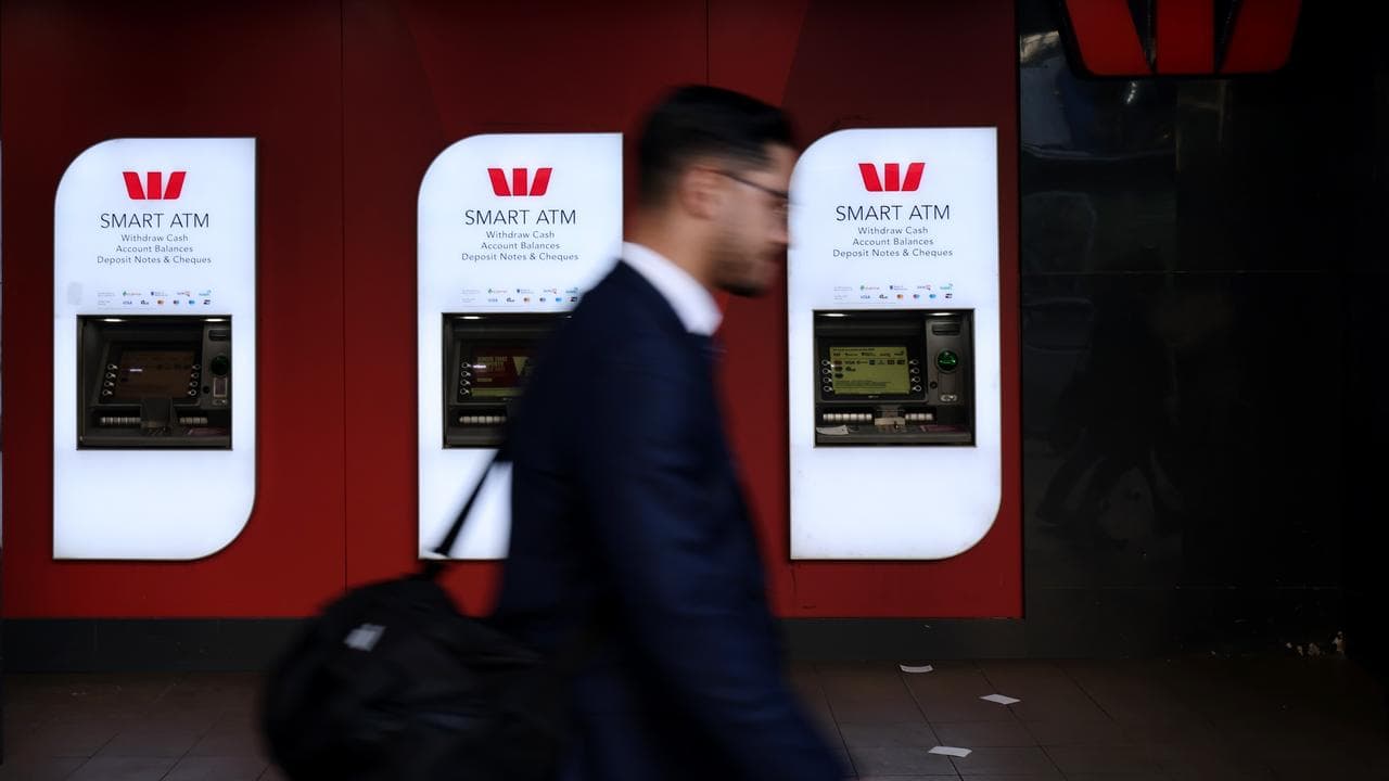A man walks past Westpac ATMs