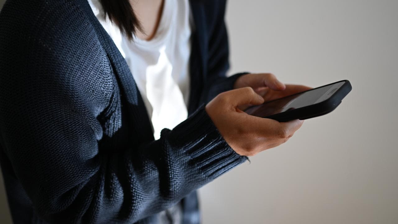 Girl holds mobile phone (file)
