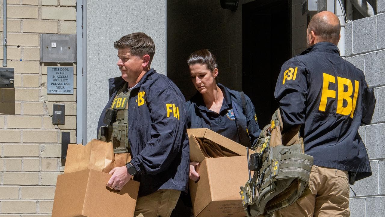 FBI agents carry boxes