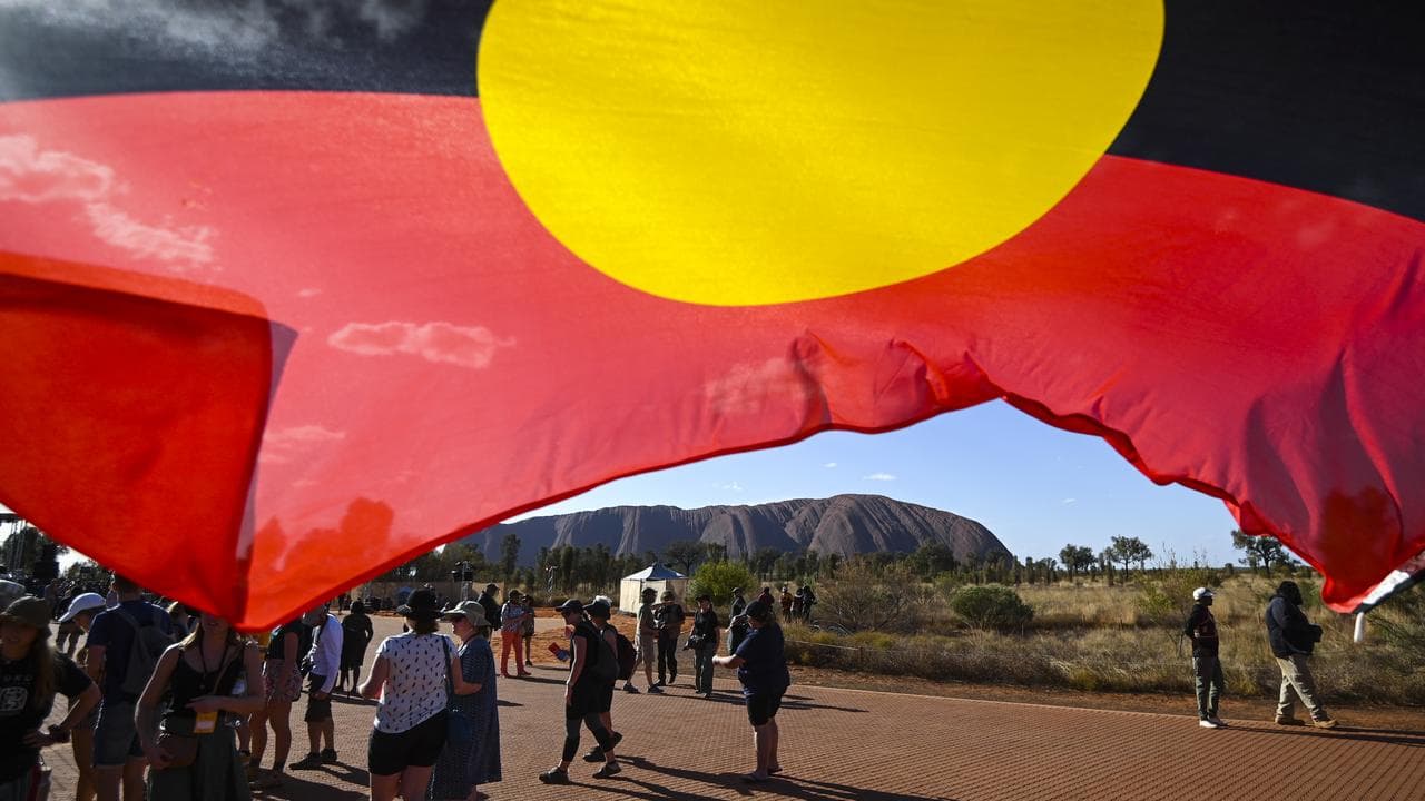 Uluru under the Aboriginal flag