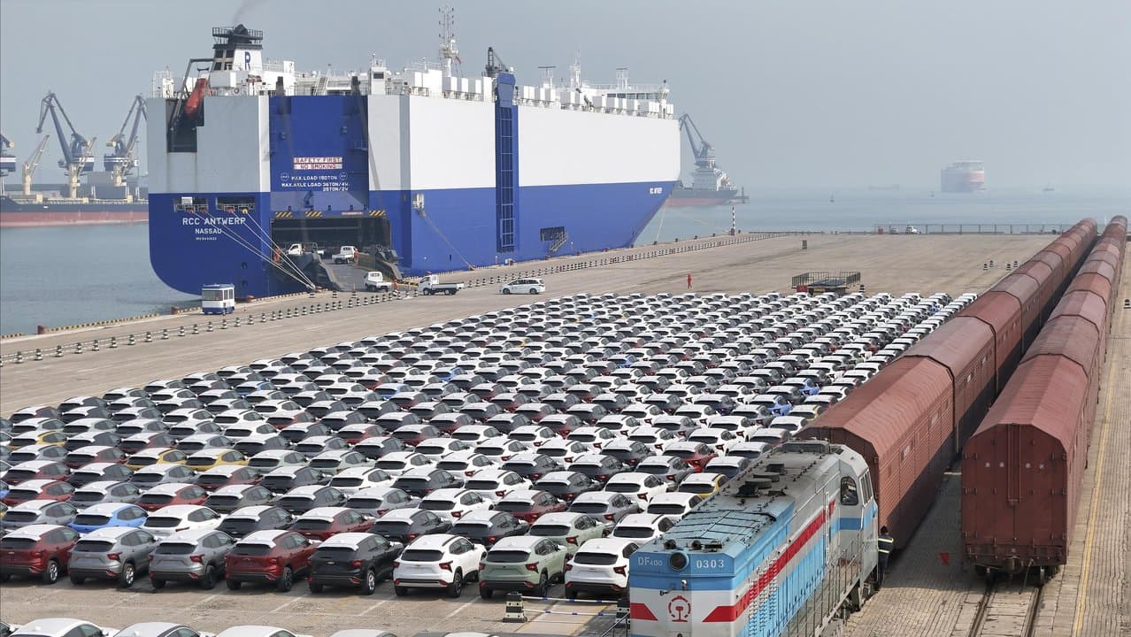 A freight train carrying cars to be exported arrives at a dock