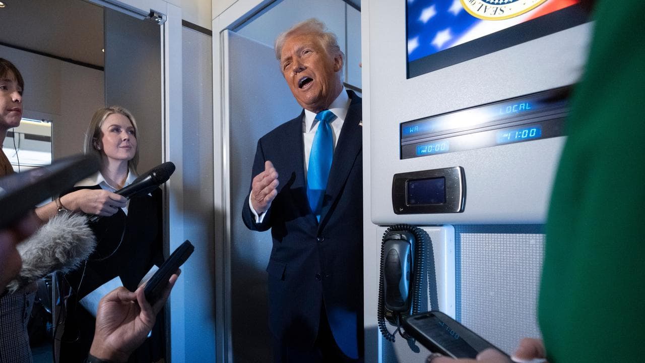 President Donald Trump speaks to reporters aboard Air Force One