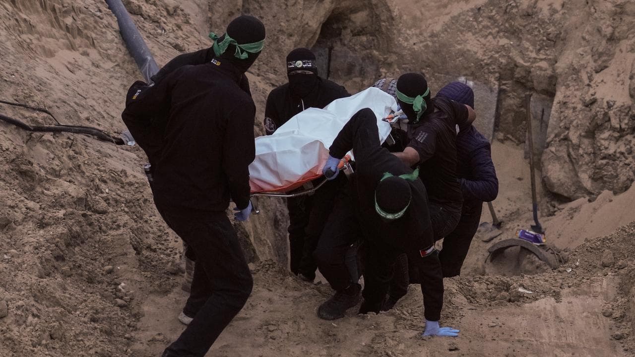 Hamas militants carry a bag believed to contain a body in Khan Younis