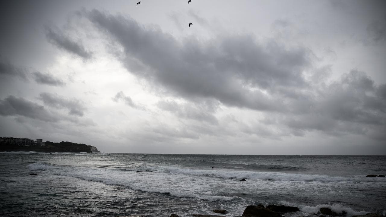 Storm clouds and surfers are seen at Bronte Beach