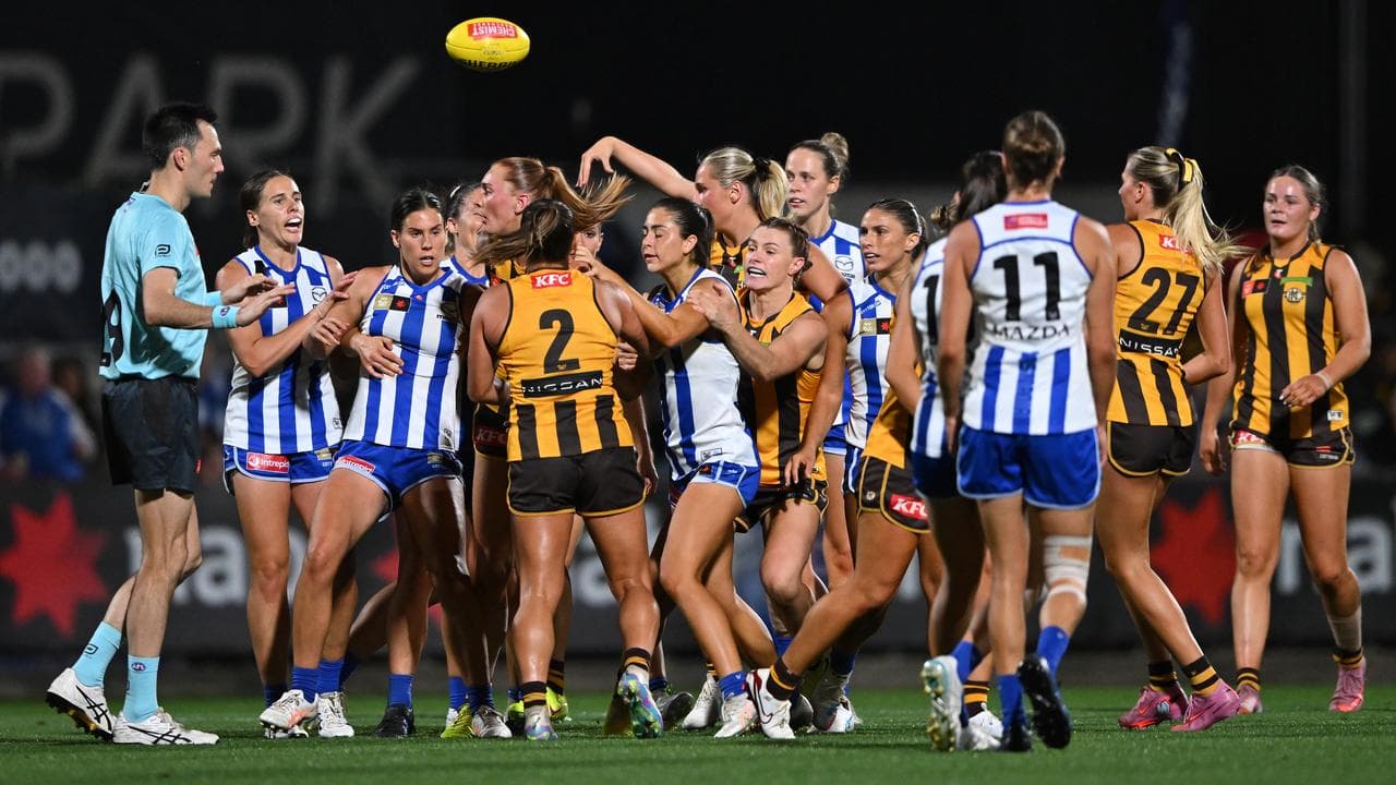 North Melbourne and Hawthorn players scuffle.